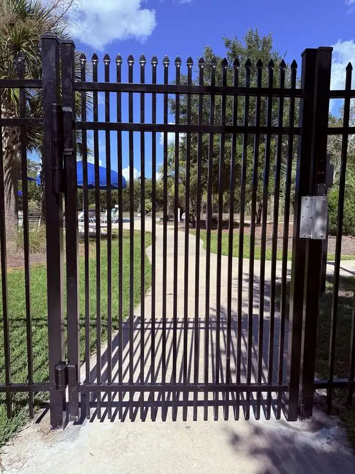 Black aluminum controlled-access pedestrian gate at the Buckhead East community pool