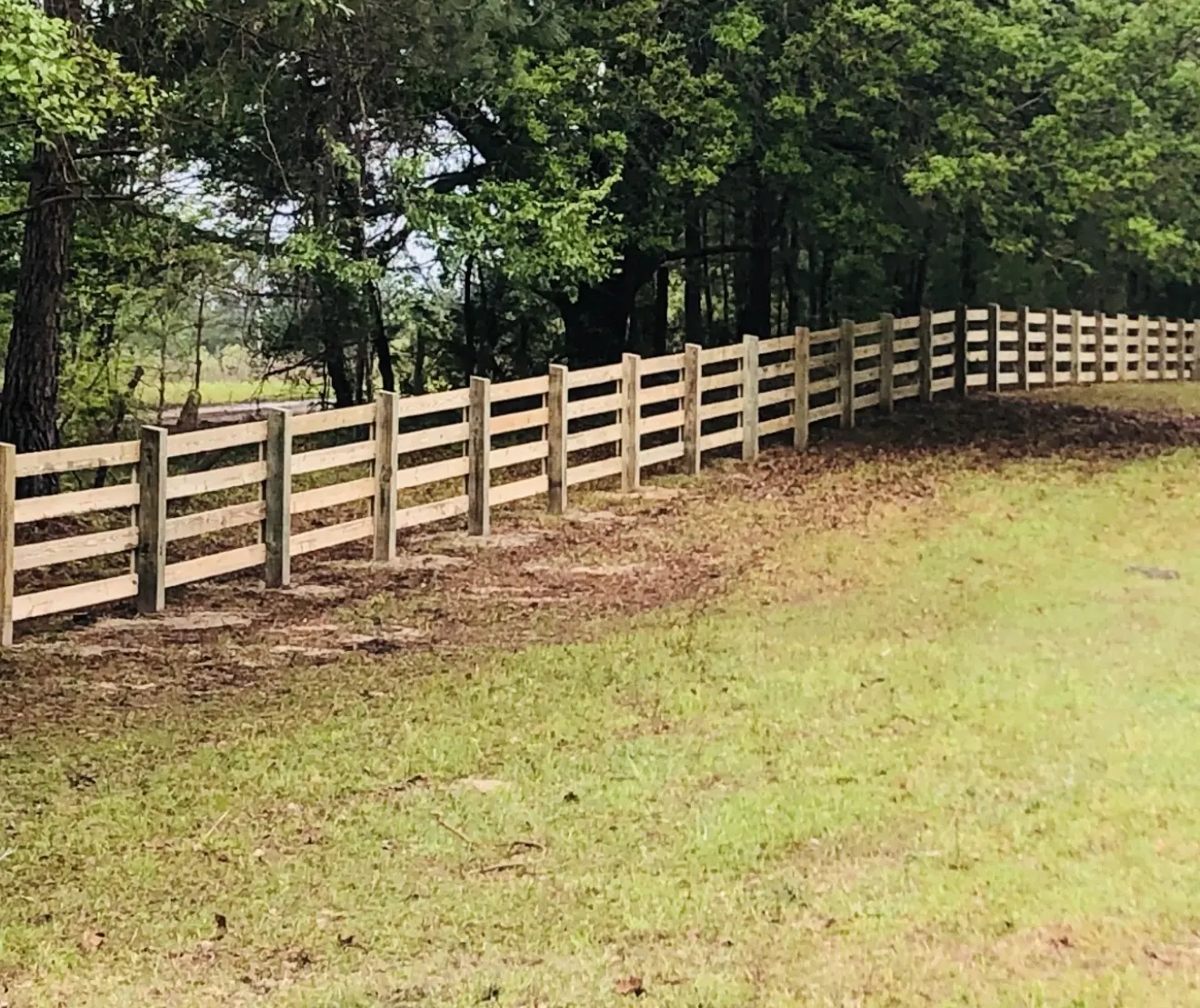 Four-board wood farm and horse fencing installed by Owens Fence Company