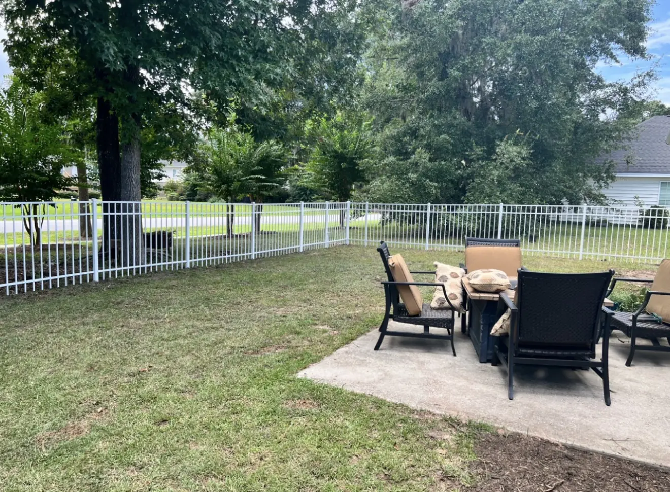 White aluminum fence surrounding a residential backyard and patio