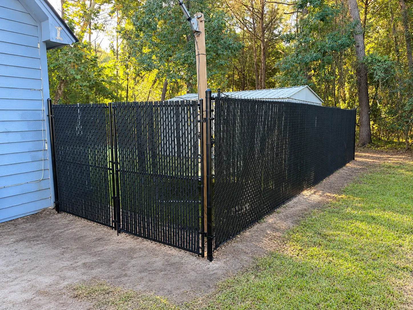 6ft black chain-link fence and gate with black privacy slats installed by Owens Contracting in the Sandfly area of Savannah, GA