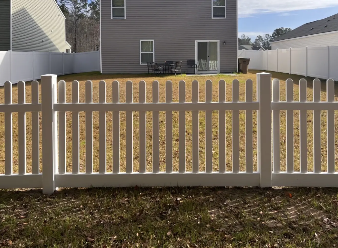 White vinyl picket fence with a matching double gate