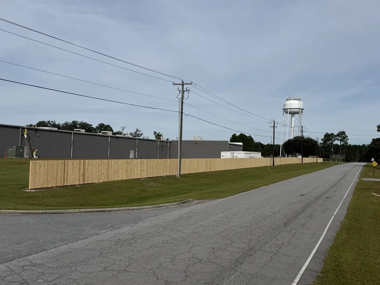 Long run of completed Walmart wood privacy fence along the roadway in Rincon